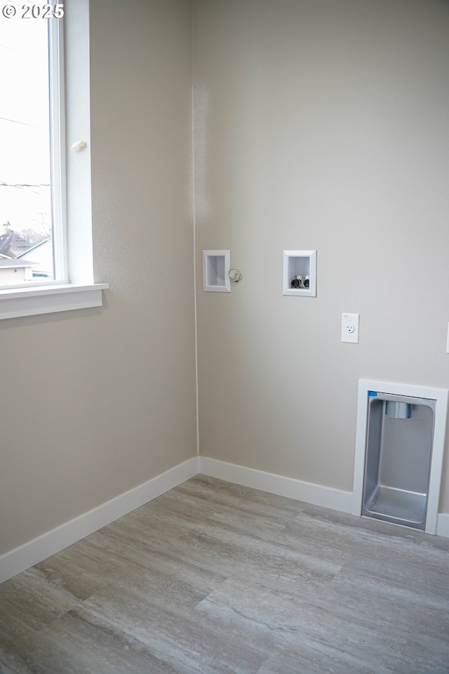 clothes washing area with washer hookup, electric dryer hookup, wood finished floors, laundry area, and baseboards