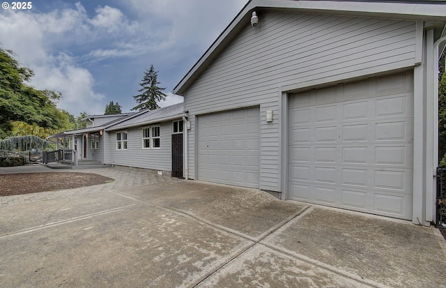 view of property exterior featuring concrete driveway and a garage