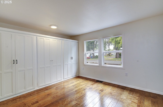 unfurnished bedroom with light wood finished floors, baseboards, and a closet