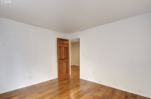 unfurnished room with light wood-type flooring and baseboards
