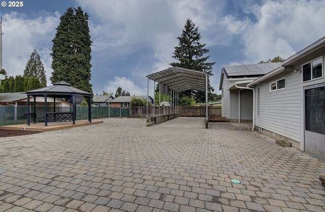view of patio with a detached carport, a gazebo, and fence