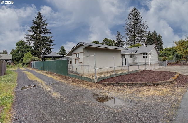 view of front of house featuring a gazebo, fence, and driveway