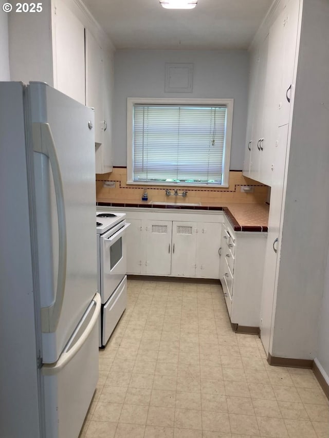 kitchen with white cabinetry, sink, and white appliances