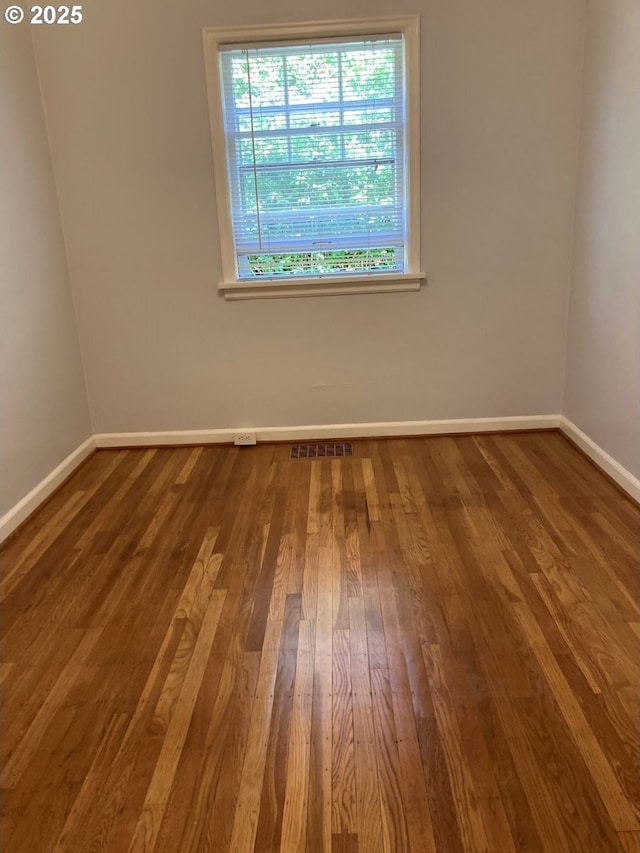 unfurnished room with hardwood / wood-style floors