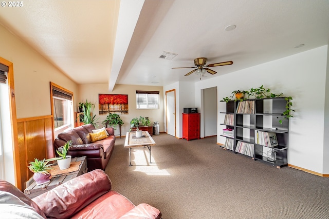 carpeted living room with beamed ceiling and ceiling fan