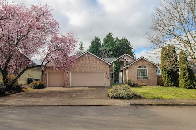 ranch-style home featuring driveway, brick siding, an attached garage, and a front yard