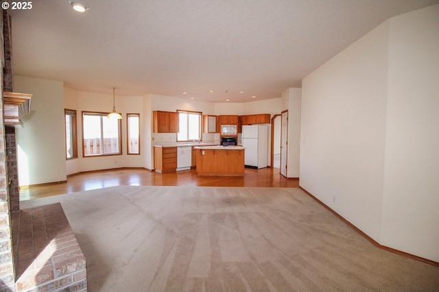 unfurnished living room featuring recessed lighting, light wood-type flooring, and baseboards