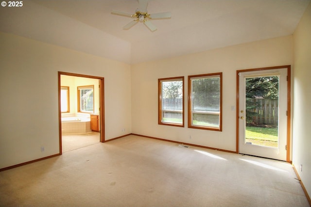 unfurnished room with visible vents, plenty of natural light, light colored carpet, and ceiling fan