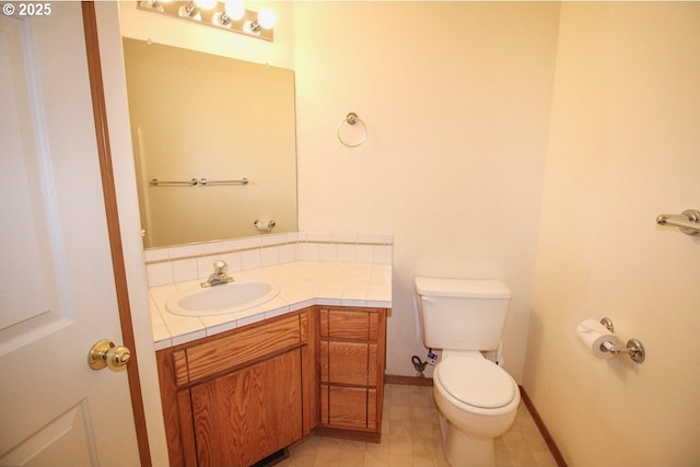 bathroom featuring vanity, toilet, and baseboards