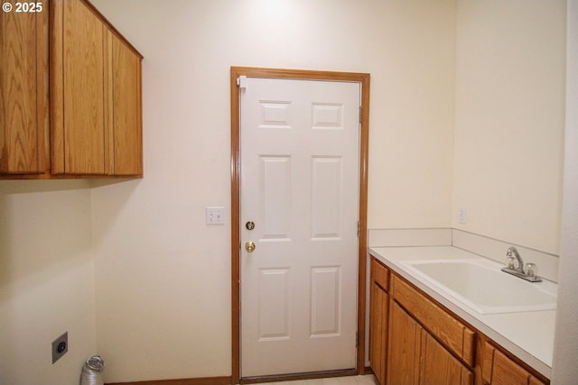 clothes washing area with a sink, cabinet space, and hookup for an electric dryer