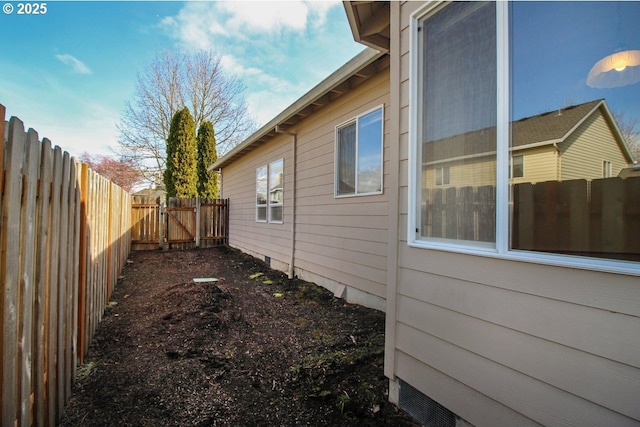 view of side of property with crawl space and fence