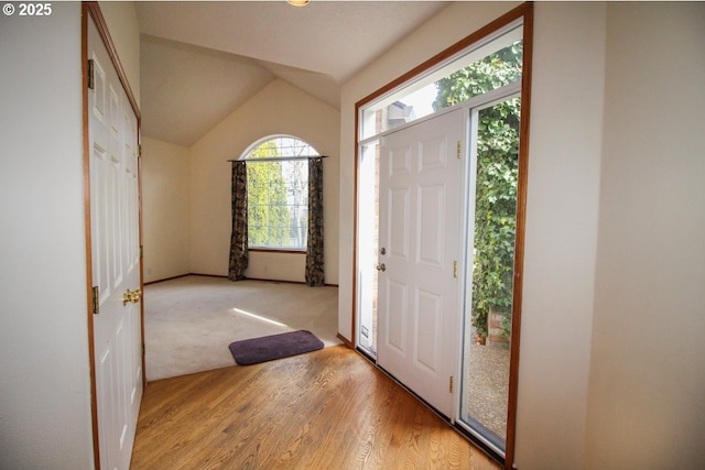 entryway featuring light wood-style flooring and vaulted ceiling