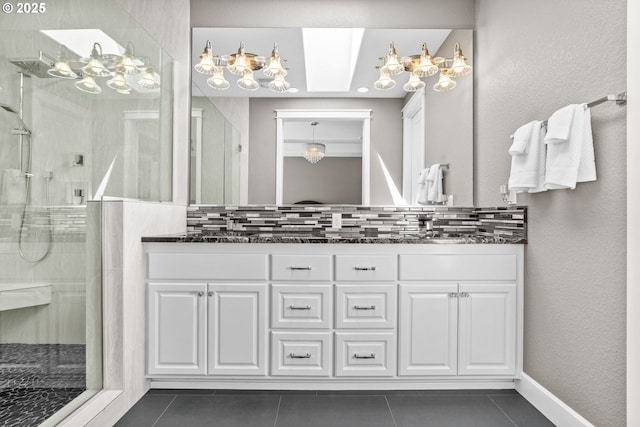 bathroom featuring a chandelier, a shower stall, and tile patterned flooring