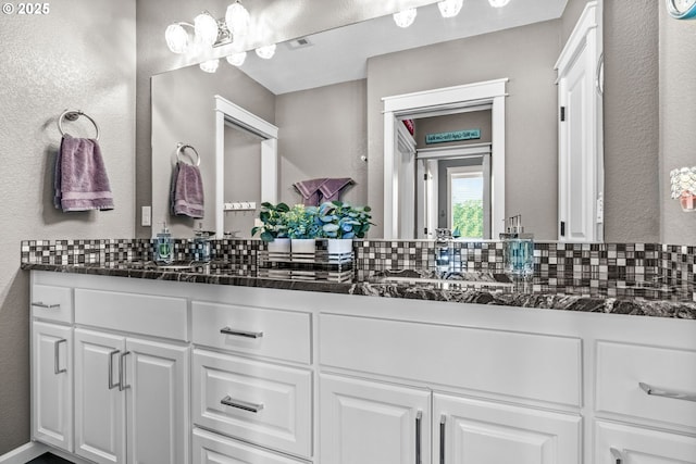 full bath with double vanity and decorative backsplash