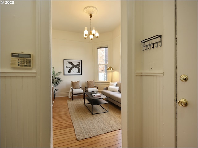 sitting room featuring hardwood / wood-style flooring and a chandelier