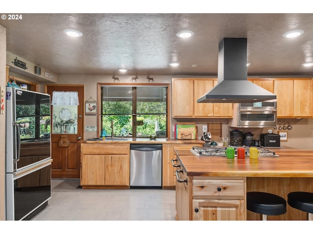 kitchen with a sink, light brown cabinets, black appliances, and island exhaust hood