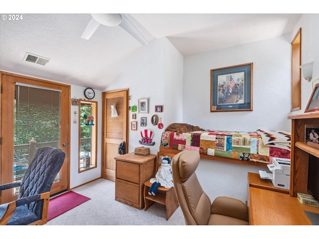 carpeted home office with visible vents, a ceiling fan, and vaulted ceiling