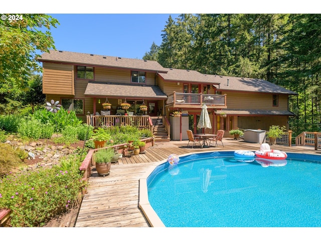 outdoor pool with outdoor dining area, stairway, and a deck