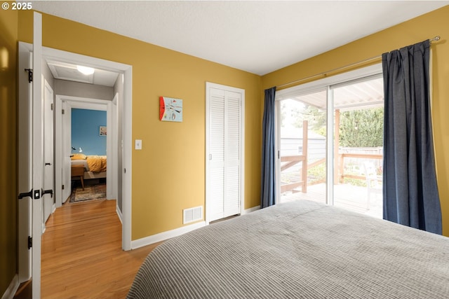 bedroom with light wood-style floors, baseboards, and a closet