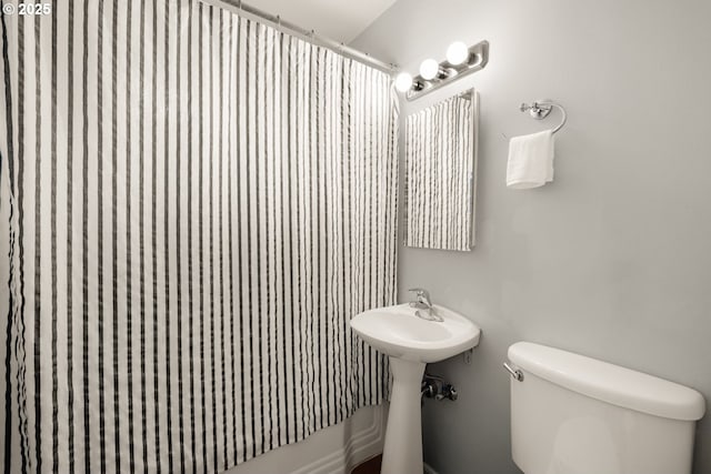 bathroom with toilet and a shower with shower curtain