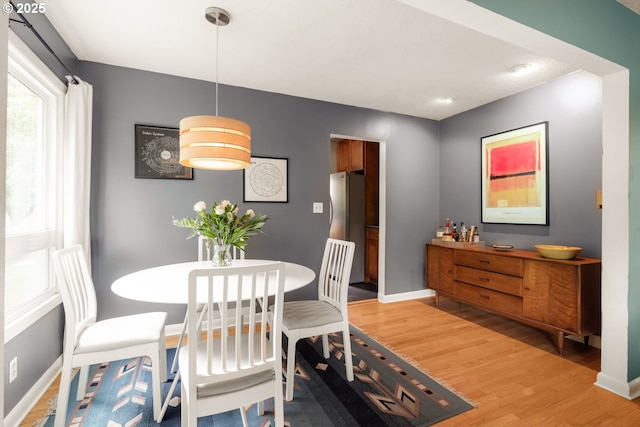 dining room featuring light wood-style flooring and baseboards