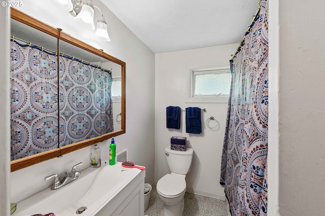 bathroom with speckle patterned floor, toilet, baseboards, a shower with curtain, and vanity