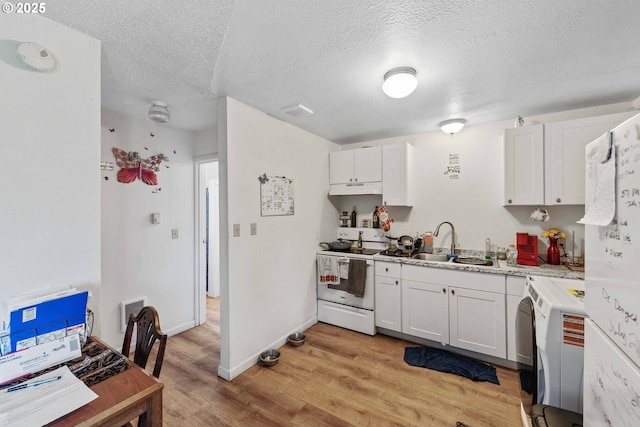 kitchen with white range with electric stovetop, a sink, under cabinet range hood, light wood finished floors, and washer / dryer