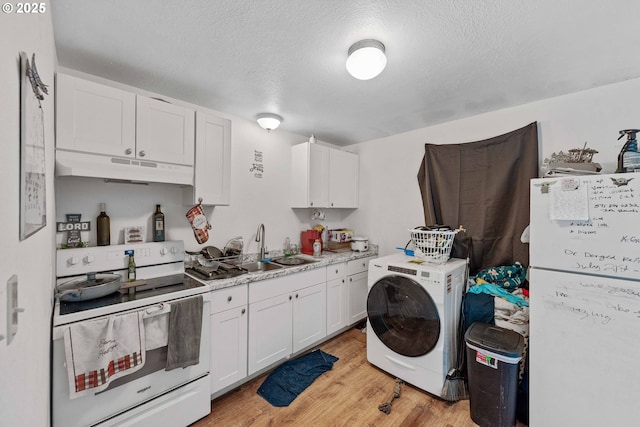 clothes washing area featuring washer / dryer, light wood finished floors, and a textured ceiling