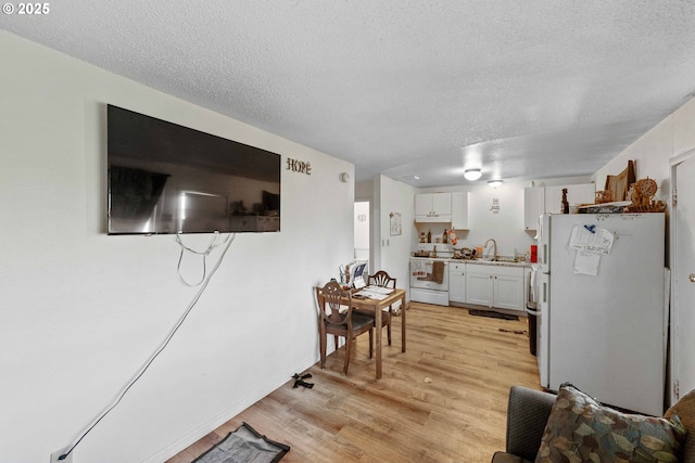 living area with a textured ceiling and light wood-type flooring