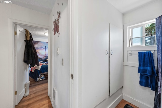 bathroom featuring a textured ceiling and wood finished floors