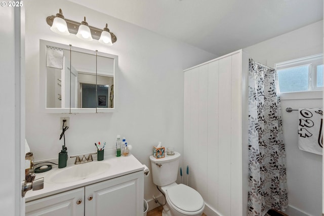 bathroom featuring toilet, vanity, and a shower with shower curtain