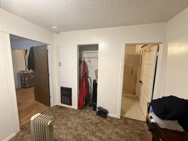 carpeted bedroom with a closet and a textured ceiling
