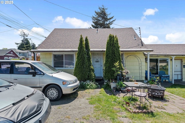 view of front of home featuring an outdoor fire pit and roof with shingles