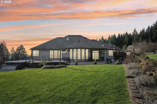 26515 NE 52nd Way, Vancouver, WA 98682 - back of property at dusk featuring a covered hot tub, a patio area, a lawn, and a wooden deck