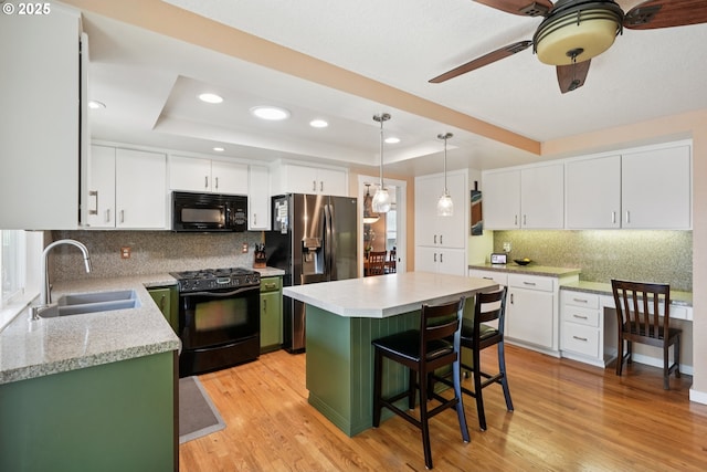 3119 SE 154th Ave, Vancouver, WA 98683 - kitchen with black appliances, a raised ceiling, decorative backsplash, light wood-style floors, and a kitchen bar