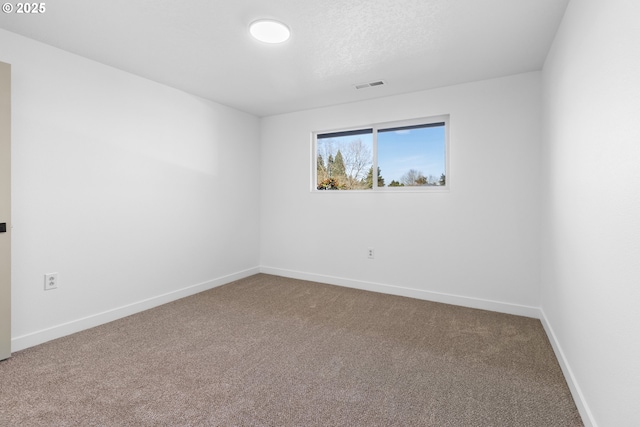 carpeted spare room featuring a textured ceiling