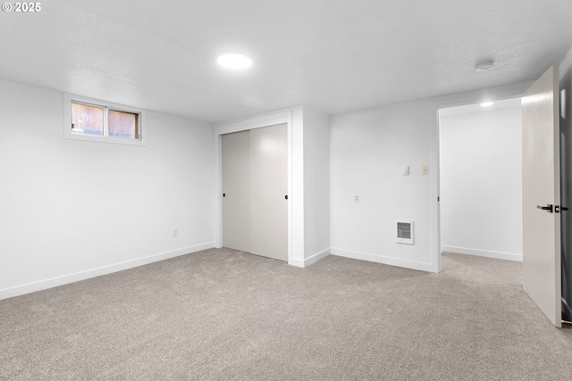 basement with light carpet and a textured ceiling