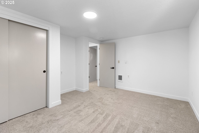 unfurnished bedroom with light colored carpet and a closet