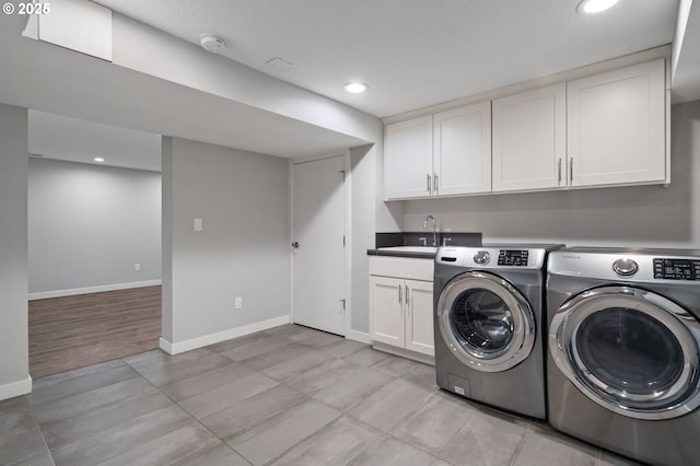 laundry room with washer and dryer, sink, and cabinets