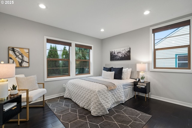 bedroom with dark hardwood / wood-style flooring and multiple windows