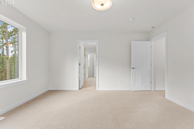 unfurnished bedroom with light colored carpet, visible vents, and baseboards