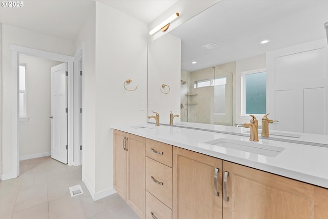 full bathroom with double vanity, a stall shower, tile patterned flooring, and a sink