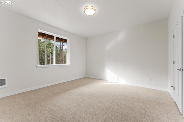 carpeted empty room featuring baseboards