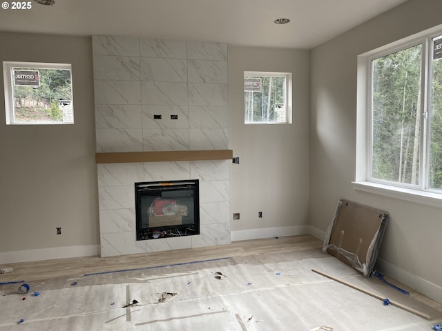 unfurnished living room featuring a tile fireplace