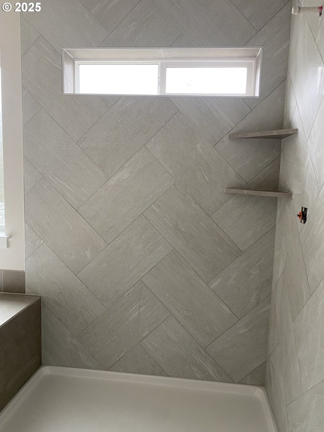 bathroom featuring tiled shower and a healthy amount of sunlight