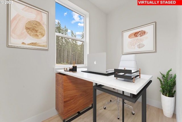 home office featuring light wood finished floors and baseboards