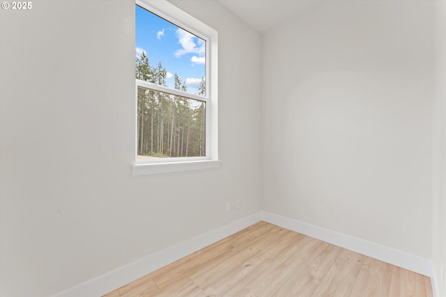 unfurnished room with baseboards and wood finished floors