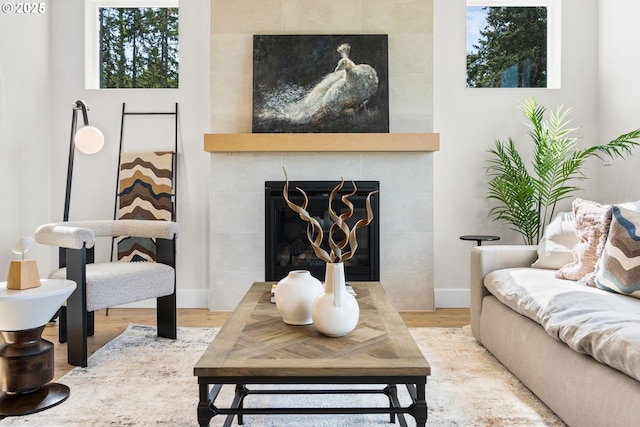 living room with a tile fireplace and hardwood / wood-style floors