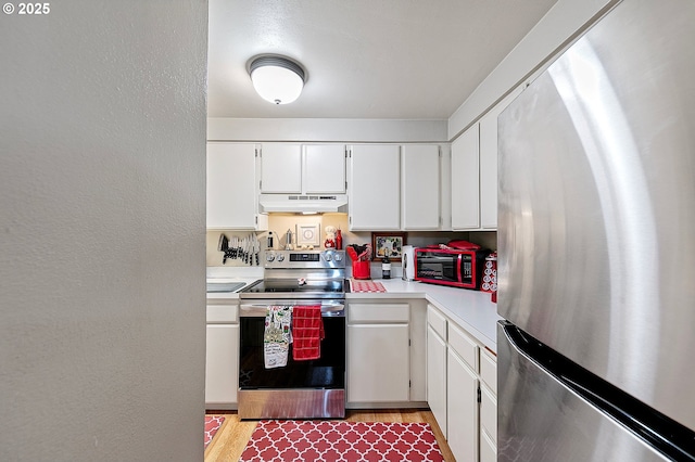 151 Treehill Loop, Eugene, OR 97405 - kitchen featuring appliances with stainless steel finishes, under cabinet range hood, light countertops, white cabinets, and light wood finished floors