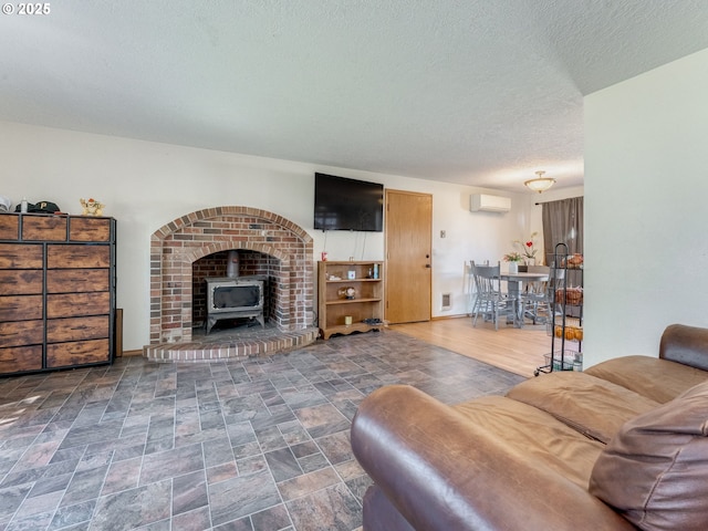 611 NW 4th Pl, Battle Ground, WA 98604 - living area featuring a wall mounted air conditioner, a wood stove, a textured ceiling, and stone finish flooring